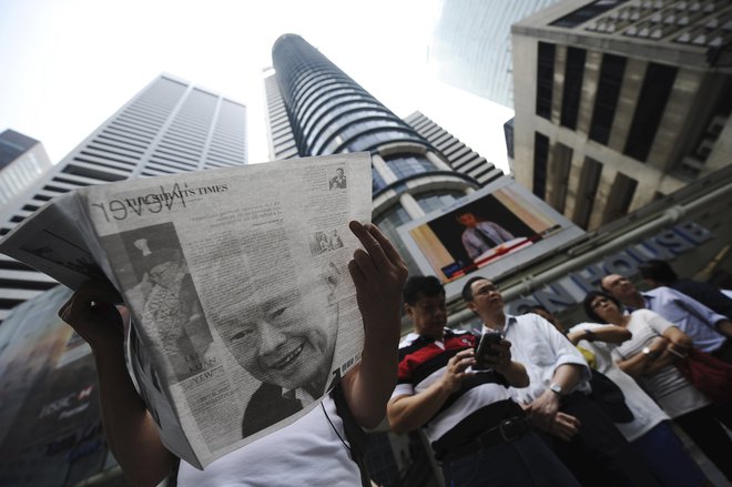 A man reads a newspaper bearing the image of Singapore's former prime minister Lee Kuan Yew, at Raffles Place in Singapore, March 23, 2015. Lee died on Monday aged 91, triggering a flood of tributes to the man who oversaw the tiny city-state's rapid rise 