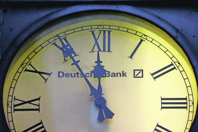A vintage clock with the logo of Deutsche Bank is pictured outside the bank's branch in Wiesbaden, Germany, January 28, 2015.  REUTERS/Kai Pfaffenbach/File Photo      - RTSQ7WB