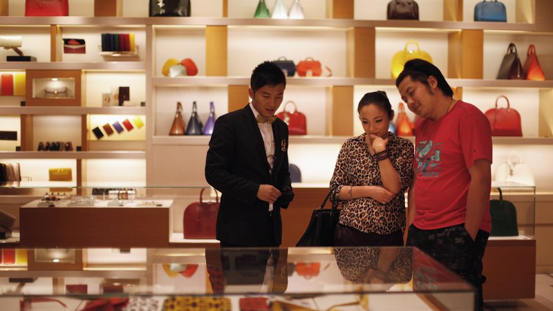 Fotografija: A couple shop at a Louis Vuitton store during Vogue's 4th Fashion's Night Out: Shopping Night with Celebrities in downtown Shanghai September 7, 2012. Louis Vuitton is courting China's wealthy with one-of-a-kind shoes and bags it is branding as unique works of art to reclaim its exclusive cachet in the luxury market. REUTERS/ Carlos Barria  (CHINA - Tags: FASHION BUSINESS SOCIETY WEALTH) - RTR37MSO
