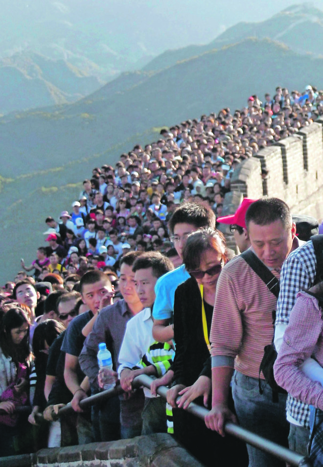 Tourists gather on the Great Wall outside Beijing, October 3, 2012. Major tourist destinations around China are witnessing travel peaks amid the eight-day Mid-autumn Festival and National Day holidays that run through until Sunday, Xinhua News Agency repo