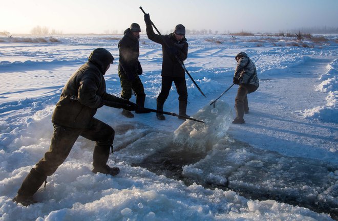 (FILES) In this file photo taken on November 27, 2018 villagers harvest ice from a local lake near the settlement of Oy, some 70 km south of Yakutsk, with the air temperature at about minus 41 degrees Celsius. - Many people in the Sakha (Yakutia) Republic