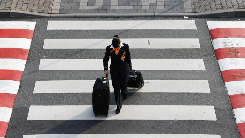 Fotografija: A Lufhansa flight attendant walks across a pedestrian crossing during a strike at the Frankfurt airport, in Frankfurt September 5, 2014. Lufthansa was counting the cost of a second pilots' strike in a week on Friday, which forced the German airline to cancel just over 200 flights from Frankfurt airport, Europe's third largest hub. REUTERS/Ralph Orlowski (GERMANY - Tags: TRANSPORT BUSINESS EMPLOYMENT SOCIETY) - GM1EA9605Q101