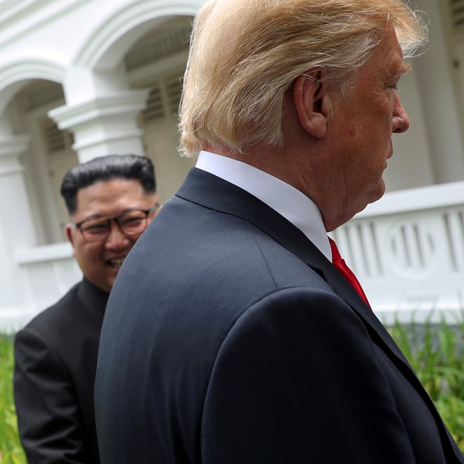 U.S. President Donald Trump and North Korea's leader Kim Jong Un walk together before their working lunch during their summit at the Capella Hotel on the resort island of Sentosa, Singapore, June 12, 2018.  REUTERS/Jonathan Ernst  SEARCH 