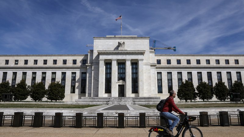 Fotografija: A man rides a bike in front of the Federal Reserve Board building on Constitution Avenue in Washington, U.S., March 27, 2019.  REUTERS/Brendan McDermid - RC182D2DB110