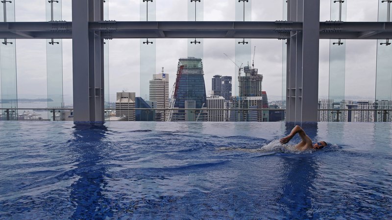Fotografija: Fitness coach Peter Yeoman swims in the pool of Gravity health and fitness club in Singapore's central business district (CBD) July 15, 2015. The S$9.5 million($7 million) luxury gym opened by British-based fitness chain Fitness First, which sits on top of an office building in the CBD, is targeted at C-Suite executives and membership is offered by-invitation only to 999 people, according to the club's press release.  REUTERS/Edgar Su  - GF10000159531