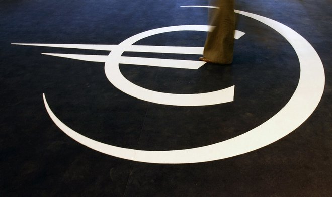A woman walks on the symbol for the euro during the inauguration of an exhibition on the 10th anniversary of the currency in Lisbon January 5, 2009. REUTERS/Nacho Doce (PORTUGAL) - GM1E51606TZ01
