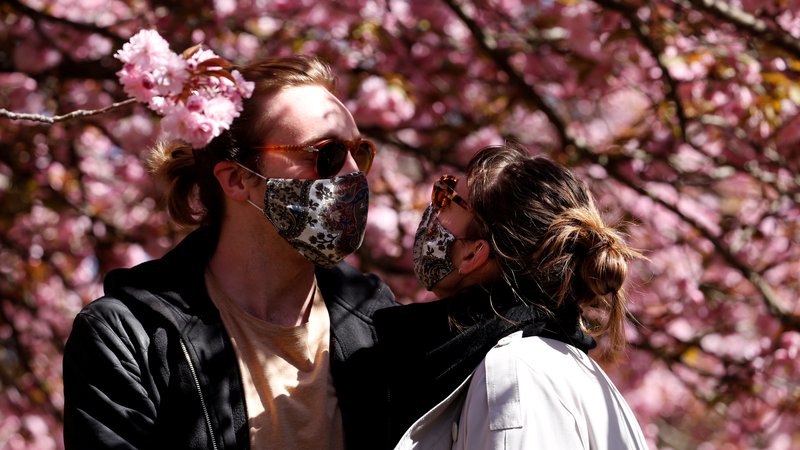 Fotografija: People wearing protective face masks stand under blooming cherry blossoms in a park on Easter Sunday, during the coronavirus disease (COVID-19) outbreak, in the Treptow district in Berlin, Germany April 12, 2020. REUTERS/Michele Tantussi TPX IMAGES OF THE DAY - RC2X2G9BGSKD