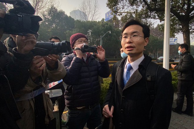 Odvetnik Zhang Keke, ki zastopa novinarko Zhang Zhana, ki je poročala o izbruhu covida-19 v Wuhanu in je bila od maja v priporu, govori pred mediji pred okrožnim ljudskim sodiščem v Šanghaju Pudong, kjer se je Zhang Zhan začelo sojenje dne 28. decembra 2020. FOTO: Leo RAMIREZ / AFP