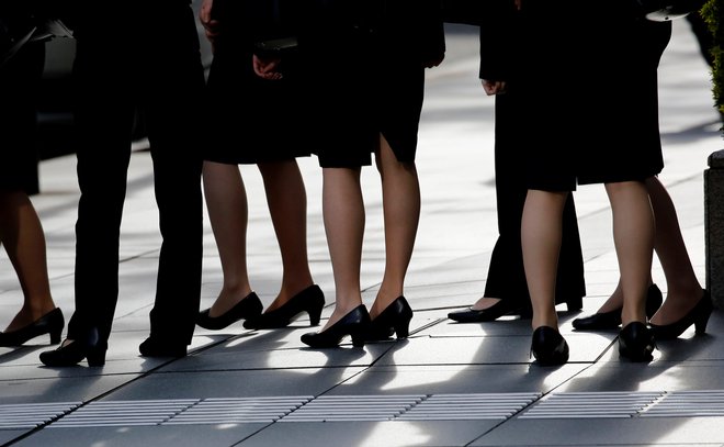 Female office workers wearing high heels, clothes and bags of the same colour are seen at a business district in Tokyo, Japan, June 4, 2019. REUTERS/Kim Kyung-Hoon - RC1A80AECD20