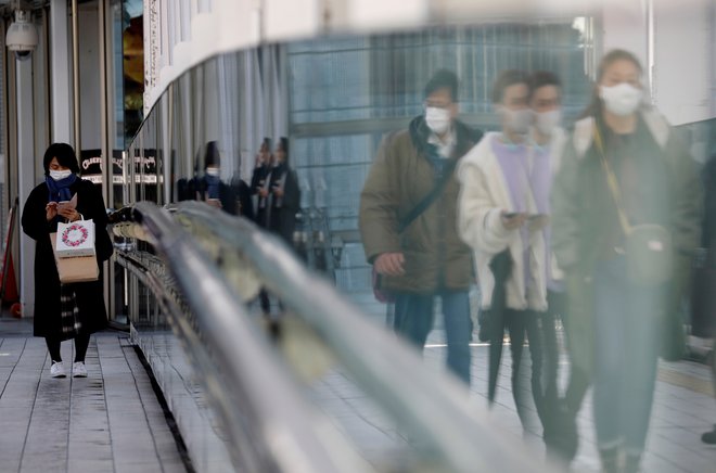 FILE PHOTO: Pedestrians wearing protective masks amid the coronavirus disease (COVID-19) outbreak, walk on a street in Tokyo, Japan, February 2, 2021. REUTERS/Kim Kyung-Hoon/File Photo