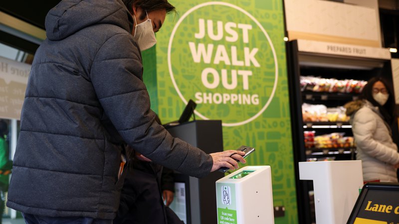 Fotografija: Stranka skenira QR kodo za vstop v prvi britanski supermarket Amazon Fresh v Londonu v Veliki Britaniji. REUTERS/Henry Nicholls