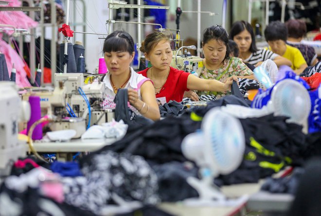 This photo taken on August 2, 2018 shows workers at a swimwear factory in Yinglin town in Jinjiang, in China's eastern Fujian Province.<br />
China's top envoy, Foreign Minister Wang Yi, called on the United States to remain "cool-headed" on August 2 as Washington threatened to raise the tariff rate on the next 200 billion USD of Chinese imports. / AFP PHOTO / STR / China OUT