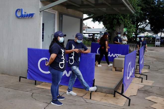 Promotorji digitalne denarnice Chiva čakajo pred bankomati Chiva, 7. september, 2021. Foto: Jose Cabezas/Reuters