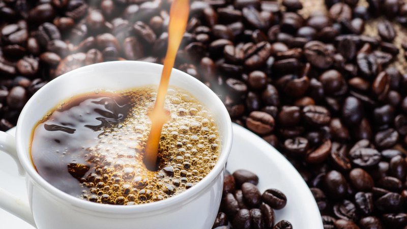 Fotografija: Skodelica kave in kavna zrna. Foto: Getty Images