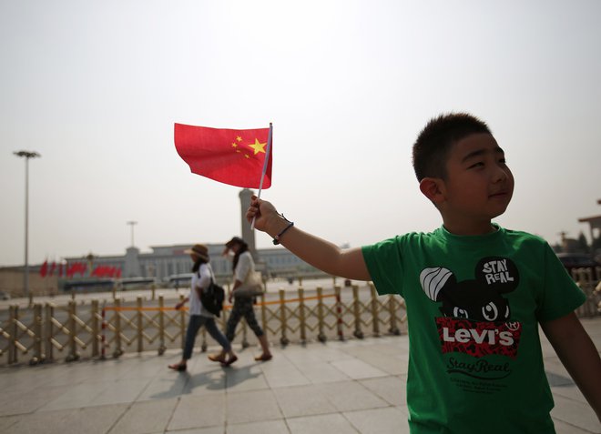 Deček pozira s kitajsko zastavo. Foto: Kim Kyung-Hoon / Reuters
