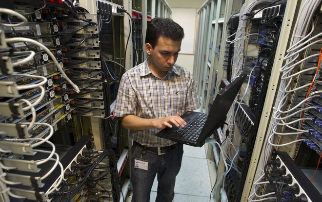 Računalniški inženir preverja opremo dobavitelja internetnih storitev. Foto: Caren Firouz / Reuters
