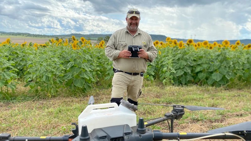 Fotografija: Roger Woods in velik kmetijski dron. Foto: Georgie Hewson / ABC News
