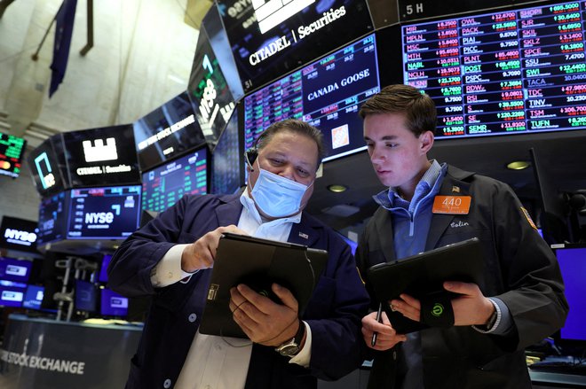Borzni posredniki delajo na newyorški borzi (NYSE) v New Yorku, ZDA, 21. marec 2022. Foto: Brendan McDermid / Reuters
