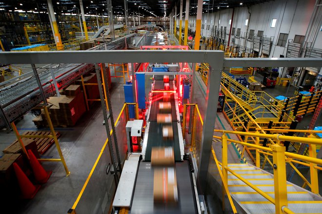 Amazonovi paketi drvijo skozi rentgen proti dostavnim tovornjakom. Foto: MIKE SEGAR/Reuters
