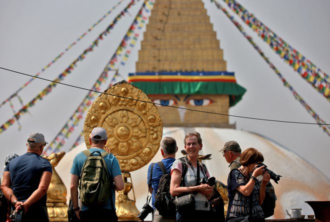 Foreign tourists take photographs of Boudhanath Stupa at a monastery in Kathmandu. Foto: MONIKA DEUPALA/Reuters

