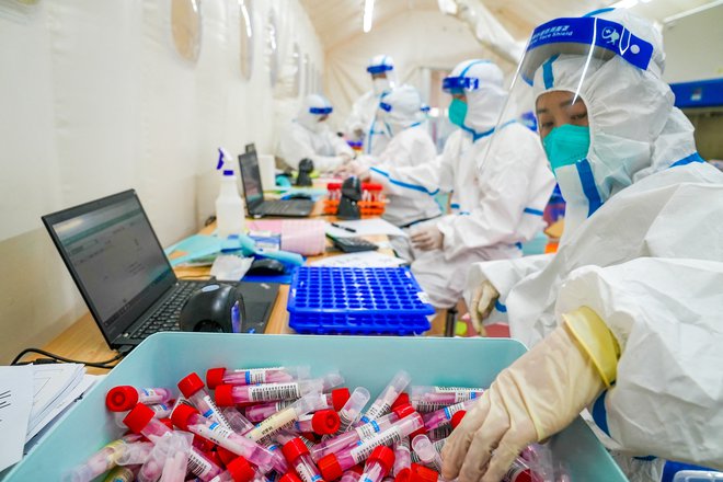 Zdravstveni delavci v začasnem laboratoriju med izbruhom koronavirusne bolezni v Pekingu na Kitajskem, 10. maj 2022. Foto: China Daily / Reuters

