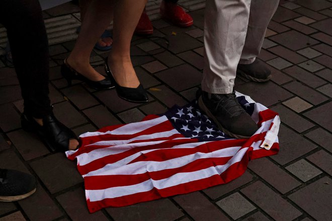 Demonstranti teptajo zastavo ZDA med protestom proti obisku predsednice predstavniškega doma ameriškega kongresa Nancy Pelosi v Tajpeju na Tajvanu. FOTO: REUTERS/Ann Wang
